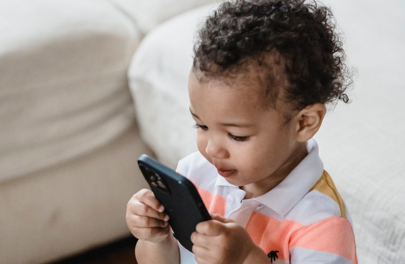 Illustrative image of a baby with a phone. (credit: PEXELS)