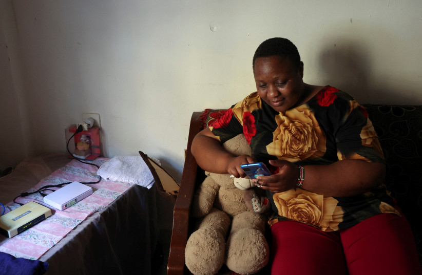  Kenyan migrant worker, Noel Musanga, uses her mobile phone during an interview with Reuters, in her apartment in Burj Hammoud, Lebanon July 1, 2022. (credit: REUTERS/MOHAMED AZAKIR)