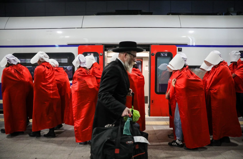A group of women dressed in costumes from the Handsmaid's Tale exit the train station as they head for the judicial reform protests, March 1, 2023. (credit: OREN CARMEL)