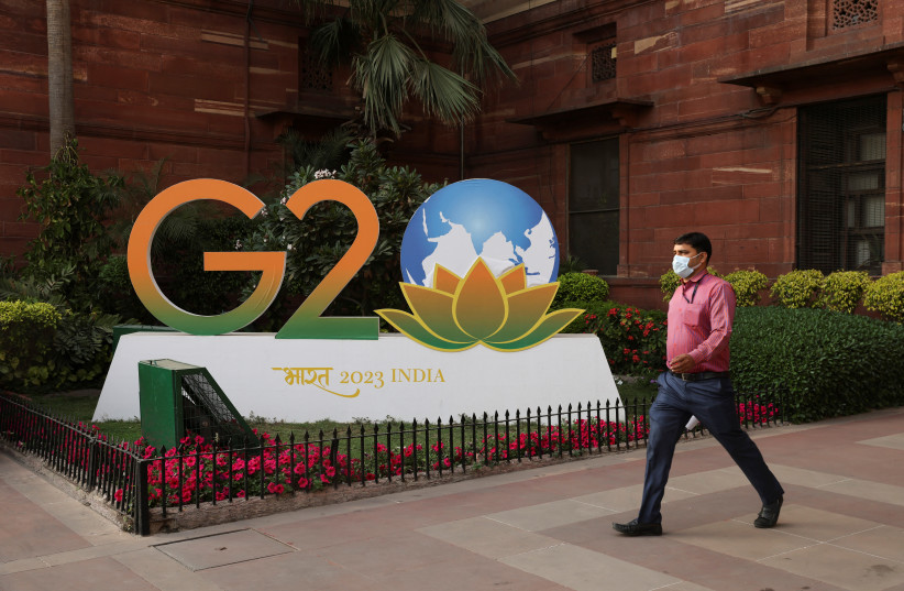  A man walks past a model of G20 logo outside the finance ministry in New Delhi, India, March 1, 2023. (photo credit: REUTERS/ANUSHREE FADNAVIS)