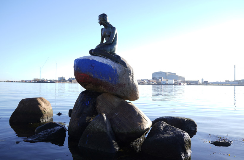  A statue of 'The Little Mermaid' is seen, created by the sculptor Edvard Eriksen and modeled after his wife, Eline, with the Russian flag painted on the stone she sits on, in Langelinie, Copenhagen, Denmark March 2, 2023 (photo credit: IDA MARIE ODGAARD/RITZAU SCANPIX/VIA REUTERS)