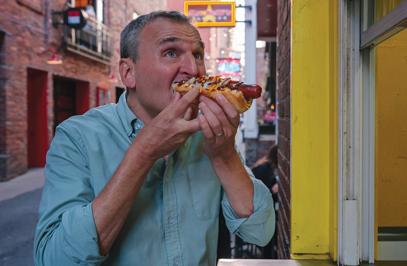  PHIL ROSENTHAL enjoys a hot dog on ‘Somebody Feed Phil.’  (photo credit: Netflix/TNS)