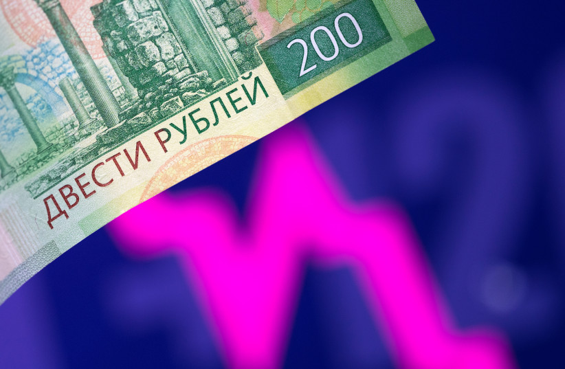  A Russian rouble banknote is seen in front of a descending stock graph in this illustration taken March 1, 2022.  (photo credit: REUTERS/DADO RUVIC/ILLUSTRATION)