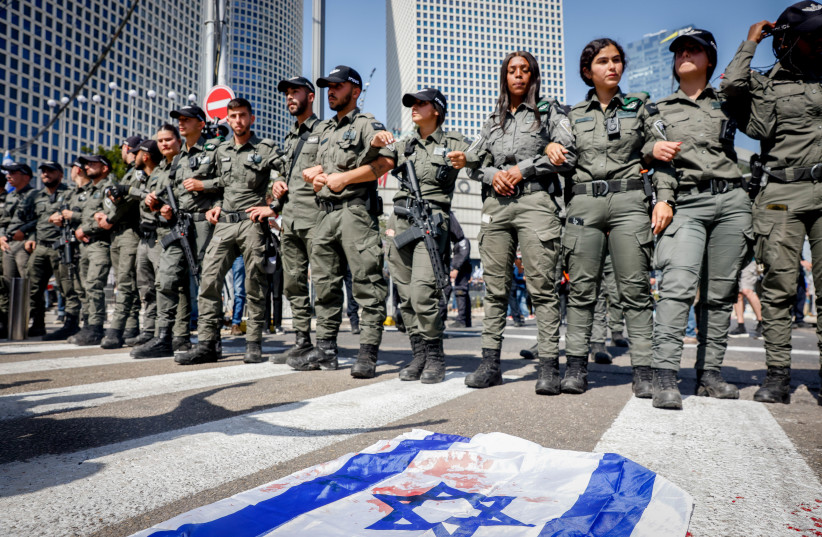  A bloodstained Israeli flag lies on the ground in Tel Aviv after police threw stun grenades into a crowd of judicial reform protersters, March 1, 2023. (photo credit: ERIK MARMOR/FLASH90)