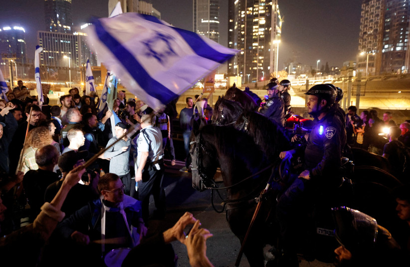 Mounted police stand in front of people during a demonstration, as Israeli Prime Minister Benjamin Netanyahu's nationalist coalition government presses on with its contentious judicial overhaul, in Tel Aviv, Israel, March 4, 2023. (photo credit: REUTERS/AMIR COHEN)