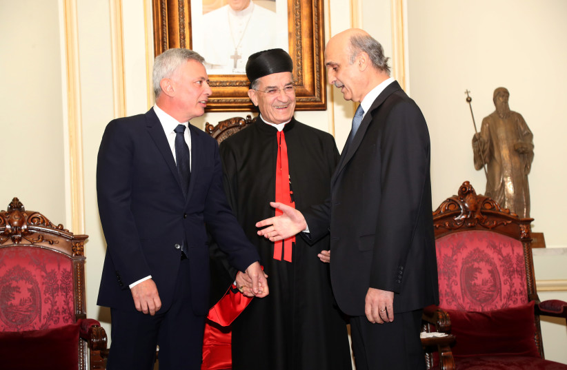 Christian Lebanese leaders Suleiman Frangieh and Samir Geagea shake hands accompanied by Patriarch Bechara al-Rai in Bkerki, Lebanon, November 14, 2018. (credit: ALDO AYOUB/HANDOUT VIA REUTERS)