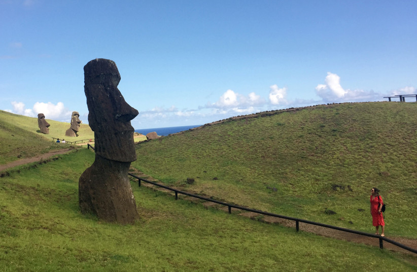  A tourist looks at a statue named "Moai" at Easter Island, Chile February 13, 2019. Picture taken February 13, 2019. (photo credit: Marion Giraldo/REUTERS)