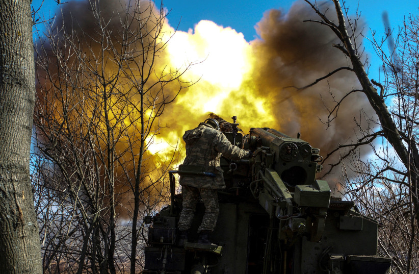 Ukrainian servicemen fire a 2S5 Giatsint-S self-propelled howitzer towards Russian troops outside the frontline town of Bakhmut, amid Russia's attack on Ukraine, in Donetsk region, Ukraine, March 5, 2023. (photo credit: REUTERS/ANNA KUDRIAVTSEVA)