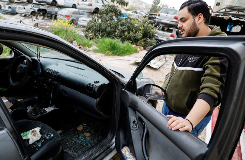  Palestinian Omar Khalifa, 27, inspects his car, which was attached by Israeli settlers while he was in it with his family, in Huwara, the West Bank, March 7, 2023. (photo credit: REUTERS/RANEEN SAWAFTA)