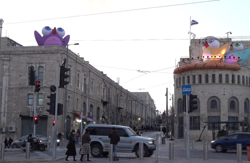 An installation of birds created by Adi Anna Telezhynski sits atop a building in the Jerusalem City Hall compound and on a rooftop opposite, March 6, 2023. (credit: GIL MEZUMAN/THE MEDIA LINE)
