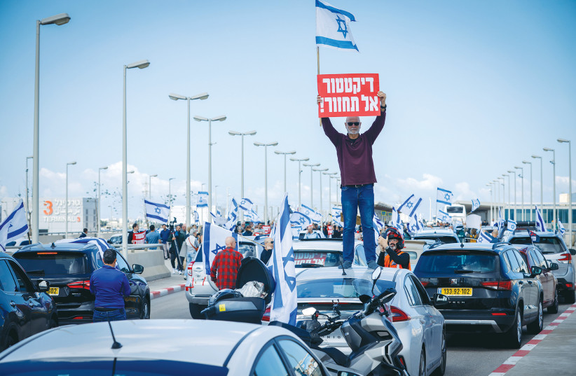  AT A protest at Ben-Gurion Airport yesterday, a man holds a sign that reads ‘Dictator: Don’t return!’ as Prime Minister Benjamin Netanyahu flew to Italy.  (credit: ERIK MARMOR/FLASH90)