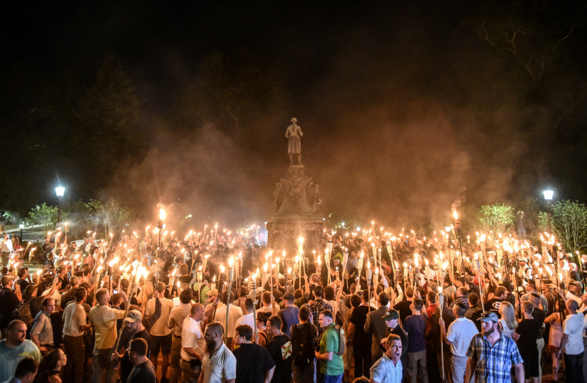 White nationalists participate in a torch-lit march on the grounds of the University of Virginia ahead of the Unite the Right Rally in Charlottesville, Virginia on August 11, 2017. (photo credit: REUTERS/STEPHANIE KEITH/FILE PHOTO)