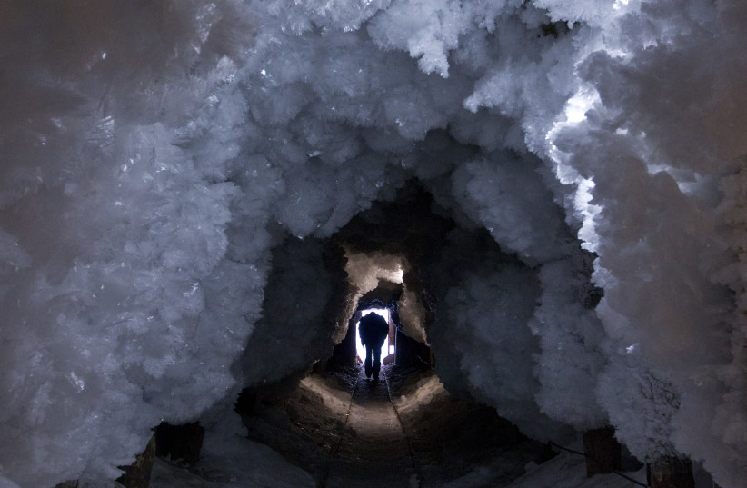 A man walks through a tunnel formed from crystals of permafrost outside the village of Tomtor in the Oymyakon valley in northeast Russia, January 28, 2013. (credit: REUTERS/MAXIM SHEMETOV)