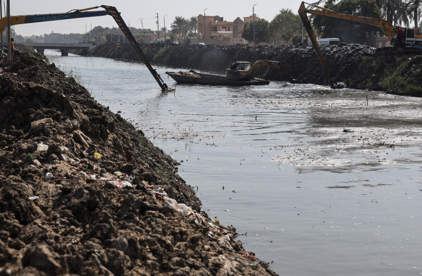 Excavators are seen on a clean up operation at sides of canal which flows into the River Nile in Giza, Egypt, October 4, 2022. (credit: REUTERS/AMR ABDALLAH DALSH)