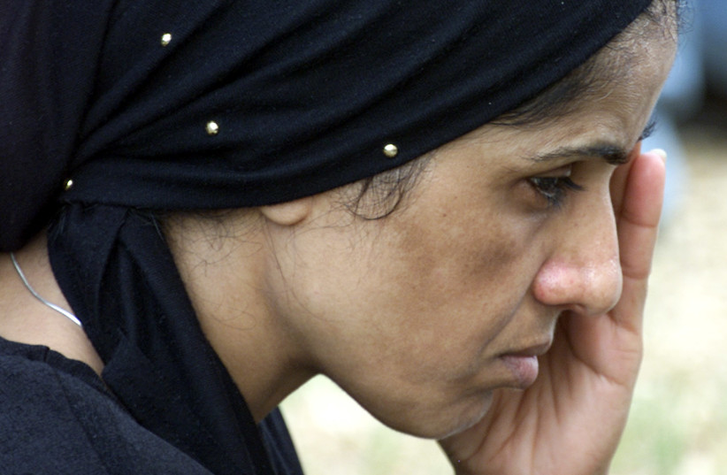  A woman mourns during the funeral of slain Jewish settler Sharon Ben-Shalom and her husband Yaniv during a ceremony in Petah Tikva August 26, 2001. Two settlers, a married couple, were killed as they drove home in the West Bank near the city of Ramallah Saturday evening. Sharon's brother, an off-du (credit: RKR/CLH/ via REUTERS)