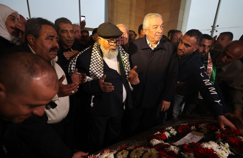  83-year-old Palestinian prisoner Fuad Shubaki (C) prays over the tomb of late Palestinian leader Yasser Arafat in the West Bank city of Ramallah on March 13, 2023, after being released from an Israeli jail after serving a 17-year sentence (photo credit:  AHMAD GHARABLI/AFP VIA GETTY IMAGES)