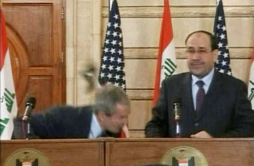  Video frame grab of US president George W. Bush ducking from a shoe during a news conference in Baghdad on December 14, 2008. (credit: REUTERS/Reuters TV)
