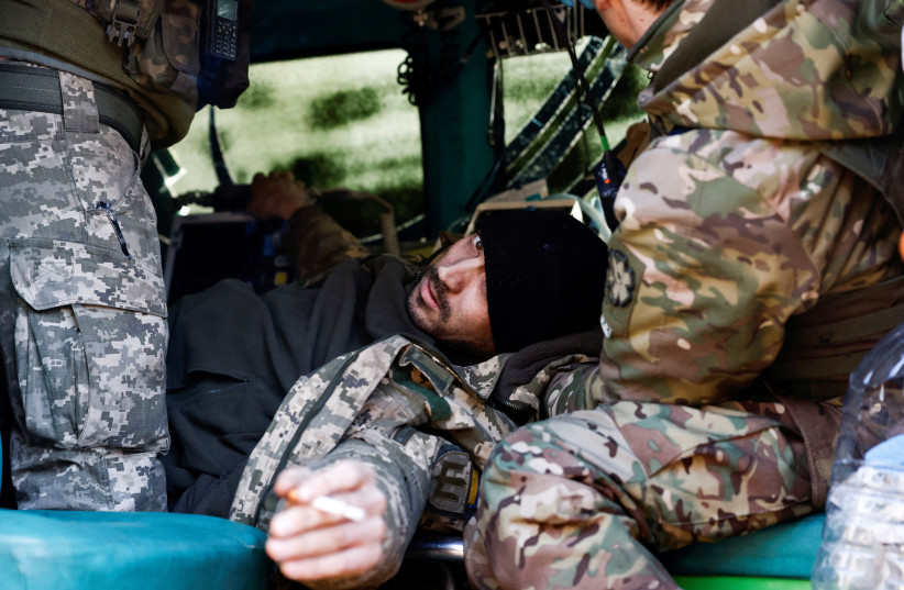  A wounded Ukrainian soldier reacts as he is treated by medics inside a frontline stabilisation ambulance, amid Russia's attack on Ukraine, in an undisclosed location near the frontline town of Kreminna, Ukraine March 13, 2023. (credit: Violeta Santos Moura/Reuters)