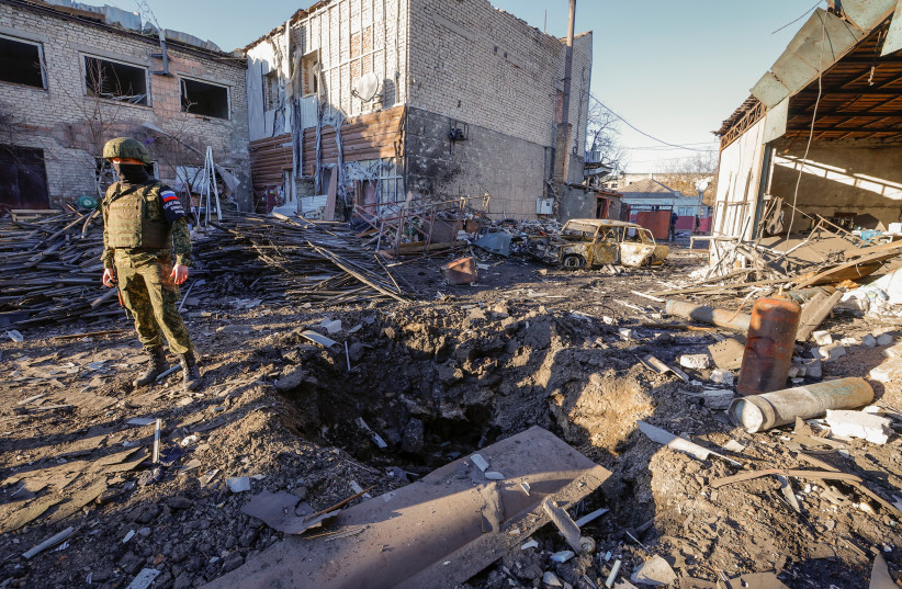  An investigator stands next to a crater in the site of recent shelling in the course of Russia-Ukraine conflict, in the town of Volnovakha in the Donetsk region, Russian-controlled Ukraine, March 13, 2023.  (credit: REUTERS/ALEXANDER ERMOCHENKO)