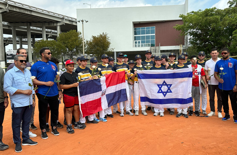  Baseball players from the David Posnack Jewish Day School pose with local Dominican teens at a ceremony March 14, 2023, in Miami.  (photo credit: JACOB GURVIS/JTA)