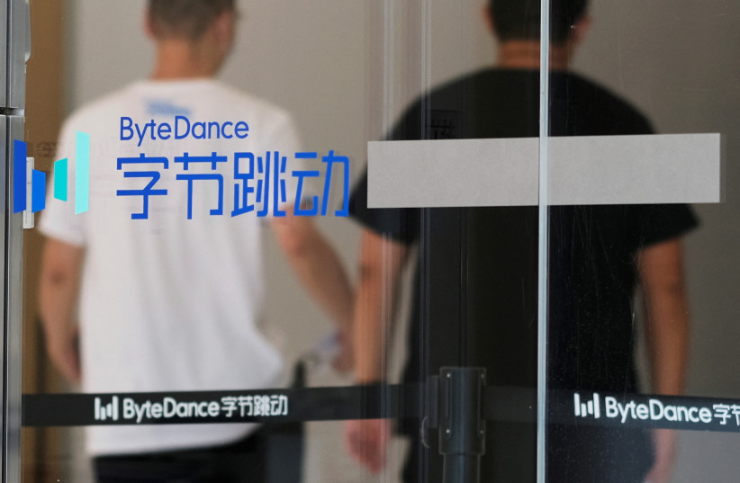 People walk past a logo of Bytedance, the China-based company which owns the short video app TikTok, or Douyin, at its office in Beijing, China, July 7, 2020. (credit: REUTERS/THOMAS SUEN/FILE PHOTO)