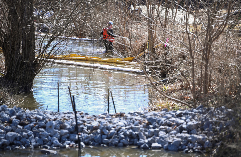  People clean up the site following the derailment of a train carrying hazardous waste in East Palestine, Ohio (photo credit: REUTERS)
