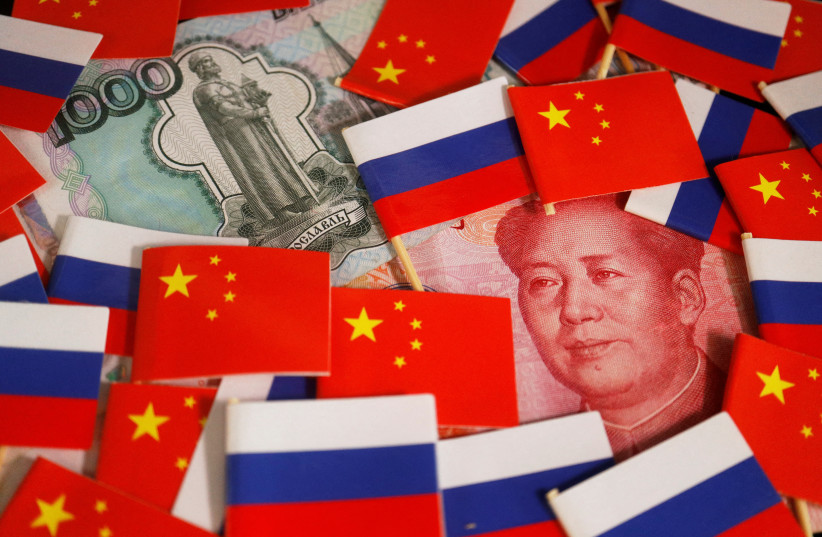  Banknotes of Chinese yuan and Russian rouble are seen amid flags of China and Russia in this illustration picture taken September 15, 2022. (photo credit: REUTERS/FLORENCE LO/ILLUSTRATION/FILE PHOTO)