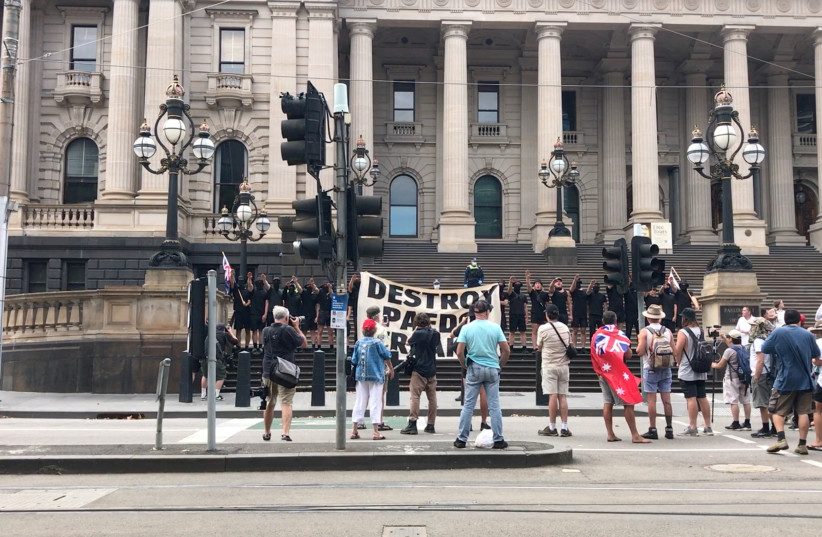 Men wearing black tops and shorts perform the Nazi salute on the steps of the Parliament House in Melbourne, Australia March 18, 2023 in this picture obtained from a social media video (photo credit: Lens of Compassion VIA REUTERS)