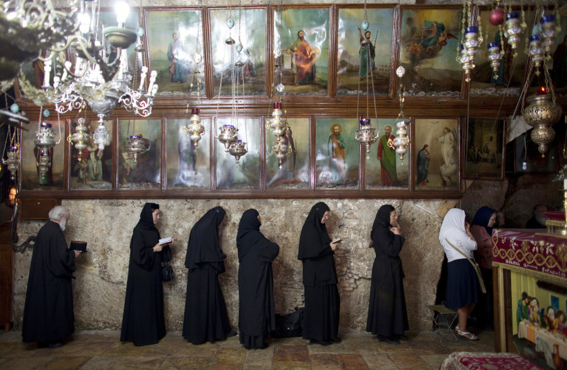 Orthodox nuns pray inside the Church of the Assumption, believed by Christians to mark the tomb of the Virgin Mary, at the foot of the Mount of Olives outside Jerusalem's Old City September 5, 2011 (credit: REUTERS/DARREN WHITESIDE)