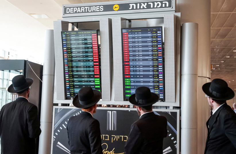  Travelers look at a monitor displaying delayed flights after take-offs were suspended as part of nationwide protests against the government's judicial overhaul plan at Ben Gurion International Airport in Lod, Israel March 27, 2023 (credit: REUTERS/ITAI RON)