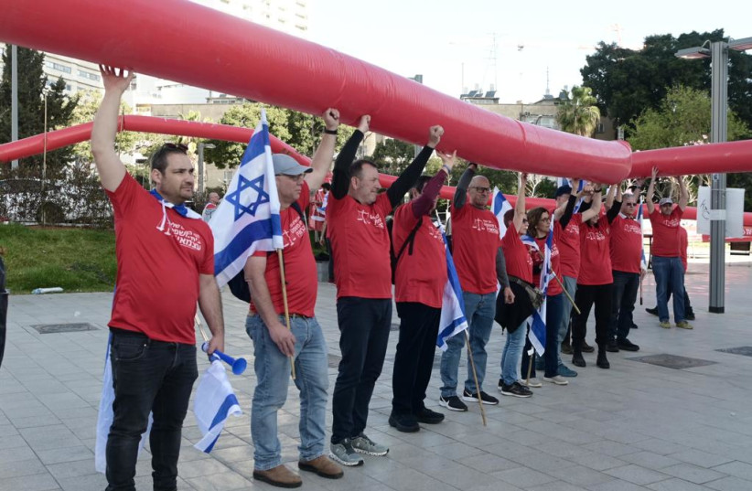 Protesters holding a red line at an IDF reservists demonstration against the judicial reform in Tel Aviv, April 4, 2023. (credit: AVSHALOM SASSONI/MAARIV)