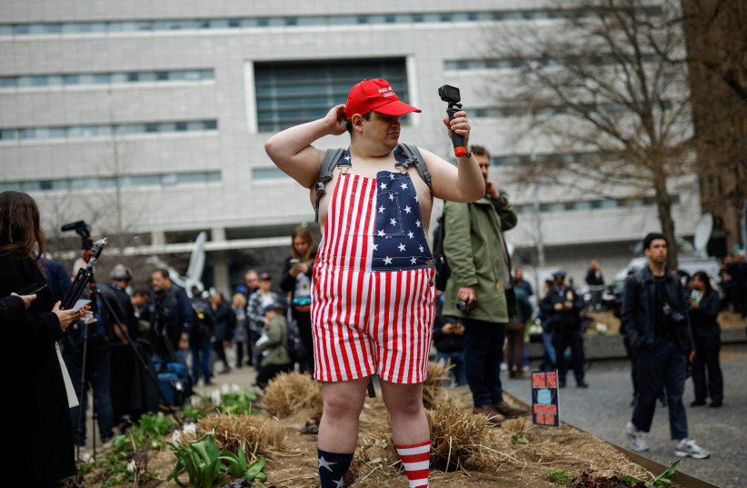 A supporter of former U.S. President Donald Trump demonstrates outside Manhattan Criminal Courthouse on the day of Trump's planned court appearance after his indictment by a Manhattan grand jury following a probe into hush money paid to porn star Stormy Daniels, in New York City, U.S., April 4, 2023 (credit: REUTERS/AMANDA PEROBELLI)
