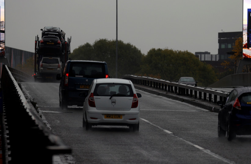  Cars drive past signs about COVID-19 measures, amid the outbreak of the coronavirus disease (COVID-19), in Manchester, Britain, October 23, 2020 (credit: PHIL NOBLE/REUTERS)