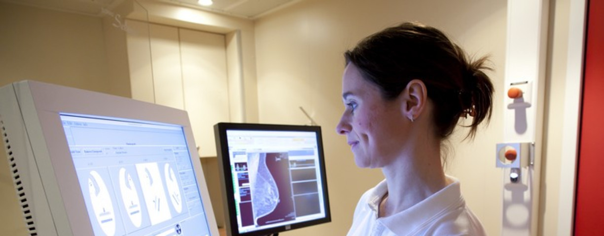 Radiology technician performs mammography test