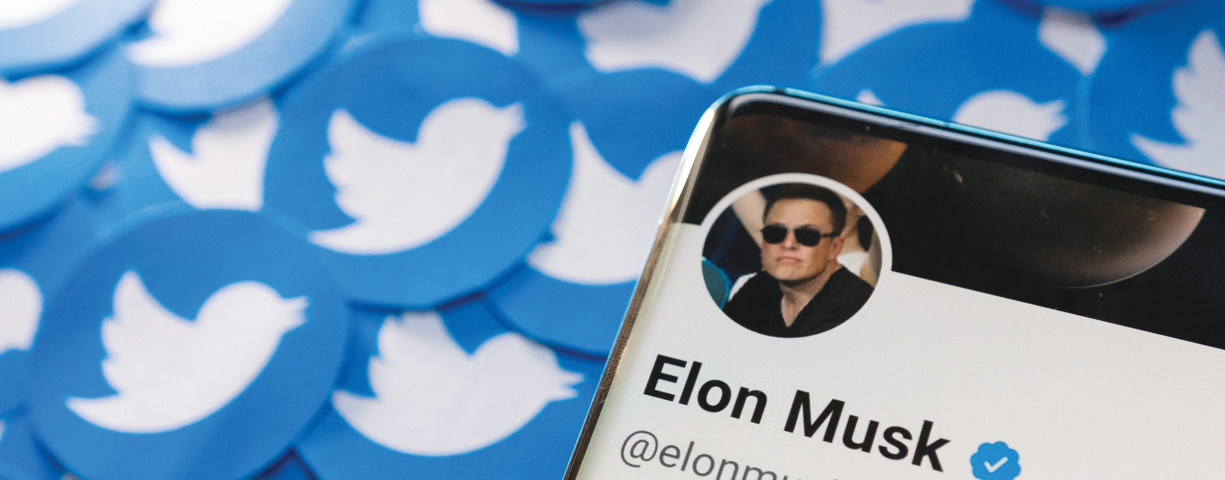  ELON MUSK’S Twitter profile is seen on a smartphone placed on printed Twitter logos in this picture illustration.