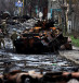  A soldier takes a photograph of his comrade as he poses beside a destroyed Russian tank and armoured vehicles, amid Russia's invasion on Ukraine, in Bucha, in Kyiv region