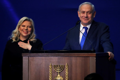 Israeli Prime Minister Benjamin Netanyahu and his wife Sara react following the announcement of exit polls in Israel's election at his Likud party headquarters in Tel Aviv