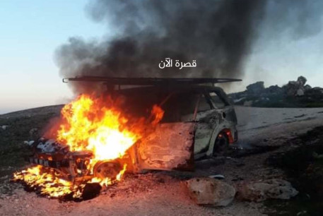 A car is seen on fire in the West Bank town of Kusra.