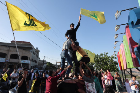  Supporters of Lebanon's Hezbollah leader Sayyed Hassan Nasrallah, gather as they carry flags, marking the commemoration of Israel's withdrawal from southern Lebanon in 2000, in Adaisseh village near the border with Israel, southern Lebanon, May 25, 2022. 