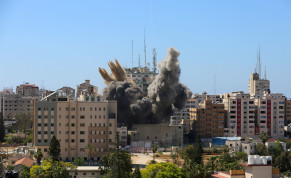 A missile falls as smoke rises near a tower housing AP, Al Jazeera offices (C) during Israeli missile strikes in Gaza city, May 15, 2021. 