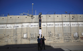  PALESTINIANS USE a ladder to climb over a section of the security barrier Al-Ram, near Ramallah, in 2015.