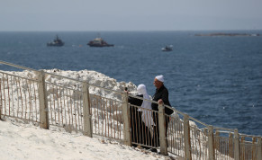  : People walk as Israeli navy boats are seen in the Mediterranean Sea as seen from Rosh Hanikra, close to the Lebanese border, northern Israel May 4, 2021. 