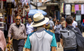  A man wearing a hat during a hot sunny summer day walks near the Tower of David in Jerusalem Old City on June 23, 2022. 