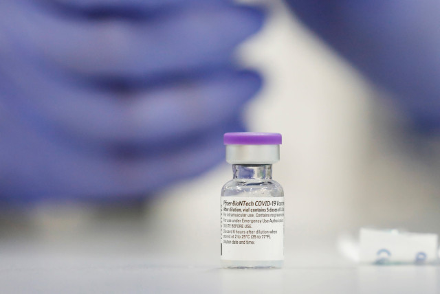 A vial of the Pfizer vaccine against the coronavirus disease (COVID-19) is seen as medical staff are vaccinated at Sheba Medical Center in Ramat Gan, Israel (photo credit: REUTERS/AMIR COHEN/FILE PHOTO)