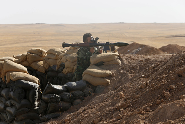 A Kurdish peshmerga fighter takes up position with a rocket-propelled grenade (RPG) launcher at the front line against the Islamic State, in Khazir September 7, 2014. Islamic State launched a lightning advance through northern and central Iraq in June, declaring an Islamic caliphate. With the help o (photo credit: REUTERS/AHMED JADALLAH)
