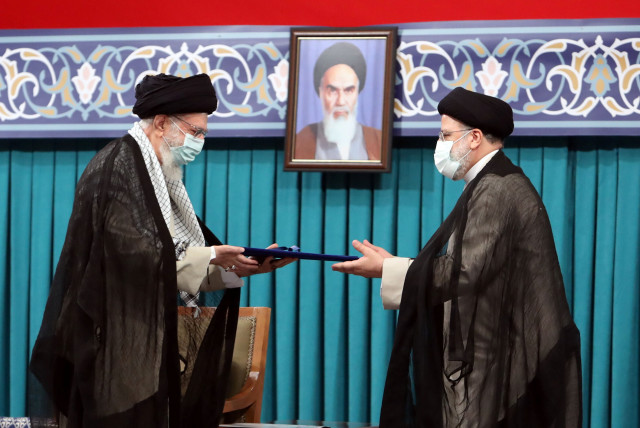 Iran's new President Ebrahim Raisi receives the endorsement decree for his presidency from Iran's Supreme Leader Ayatollah Ali Khamenei, in Tehran, Iran August 3, 2021. (photo credit: OFFICIAL KHAMENEI WEBSITE/HANDOUT VIA REUTERS)
