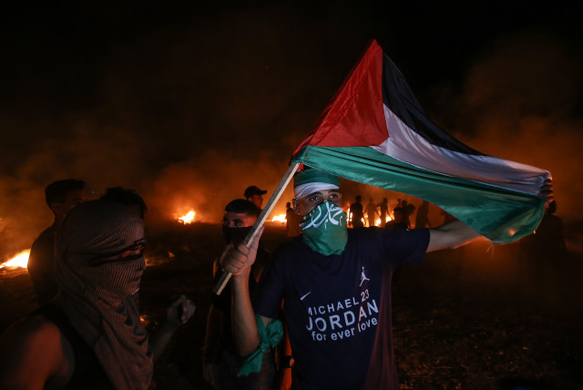  Palestinians protest at night time near the border with Israel, east of Gaza City, on August 28, 2021.  (photo credit: ATIA MOHAMMED/FLASH90)