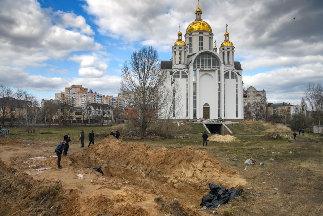 A mass grave with bodies of civilians, who according to local residents were killed by Russian soldiers, is seen, as Russia's attack on Ukraine continues, in Bucha, in Kyiv region, Ukraine April 4, 2022.  (photo credit: REUTERS/VLADYSLAV MUSIIENKO)