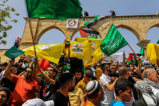  Palestinians wave flags and shout slogans as Muslim worshipers attend the last first Friday prayers of the holy month of Ramadan, at the Al Aqsa Mosque Compound in Jerusalem's Old City, Friday, April 29, 2022. (photo credit: JAMAL AWAD/FLASH90)