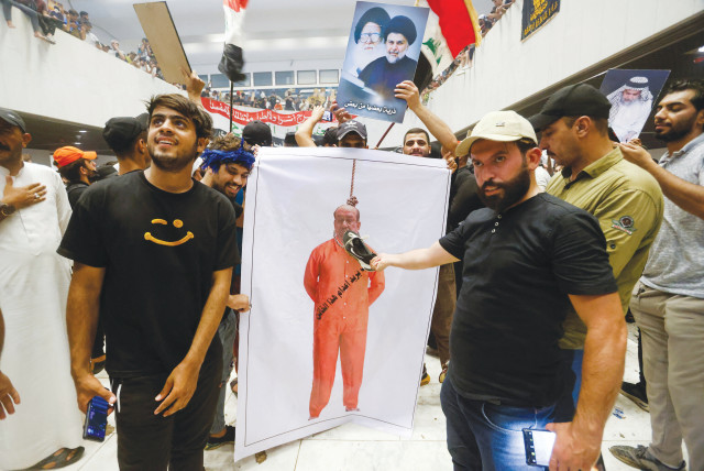  SUPPORTERS OF Iraqi Shi’ite cleric Moqtada al-Sadr hold up a banner depicting former prime minister Nouri al-Maliki, during a protest against corruption, inside the Parliament in Baghdad, on July 30.  (photo credit: AHMED SAAD/REUTERS)